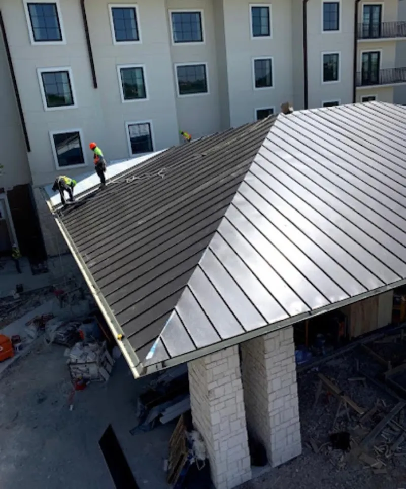 Crew installing standing seam metal roof panels on a commercial project in Long Beach